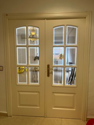 Puerta doble blanca con cristal y tiradores dorado