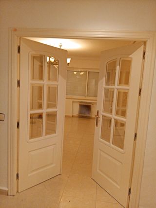 Puerta doble blanca con cristal y tiradores dorado