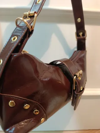 Bolso marrón con hebilla y tachuelas