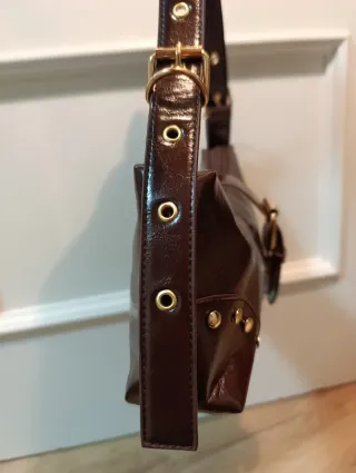 Bolso marrón con hebilla y tachuelas