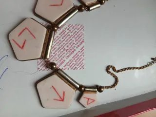 Collana con ciondoli geometrici e simboli