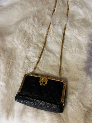 Bolso de mano negro y dorado con cadena