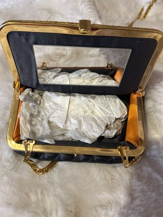 Bolso de mano negro y dorado con cadena