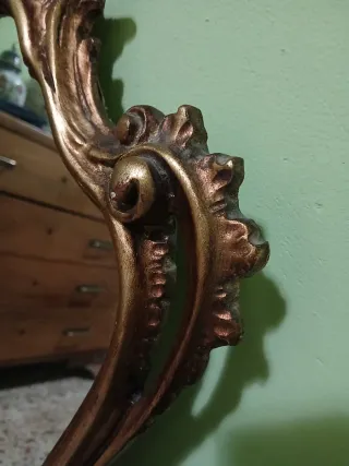 Specchio vintage con cornice in legno dorata.