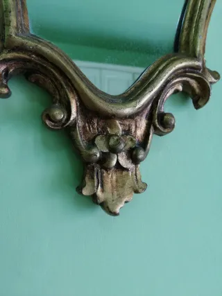 Specchio vintage con cornice in legno dorata.