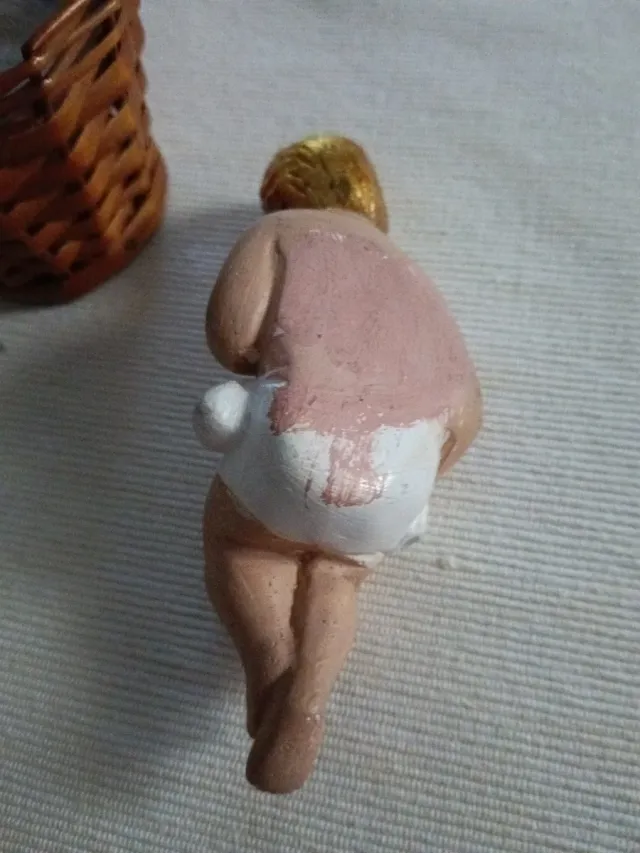 Niño Jesús artesanal en cunita de mimbre.