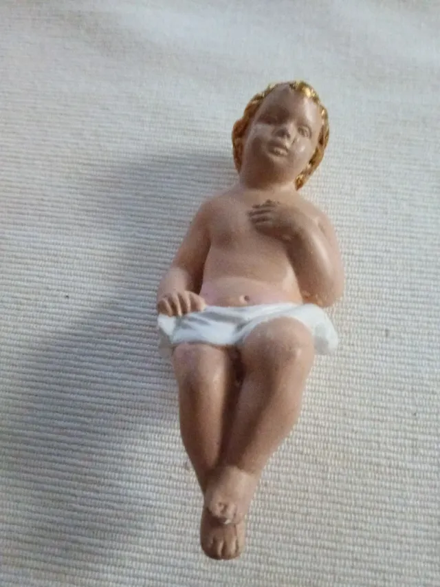 Niño Jesús artesanal en cunita de mimbre.