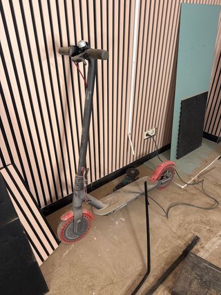 Patinete eléctrico gris con ruedas rojas fallo bat