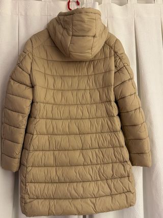 Chaqueta beige acolchada con capucha.