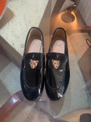 Zapatos charol negro con detalle león