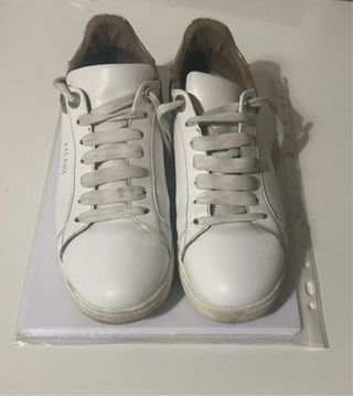 Eleganti sneakers in pelle bianca con mappa.