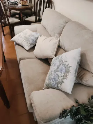 Sofá de tela beige con cojines decorativos