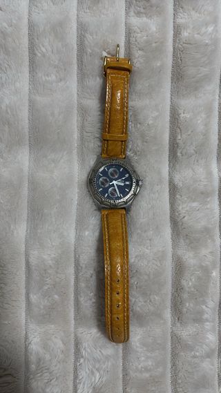 Reloj plateado con correa naranja