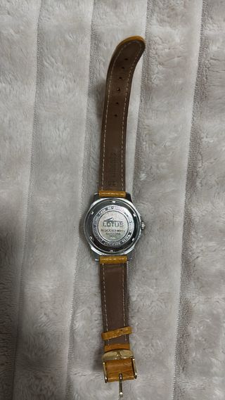 Reloj plateado con correa naranja