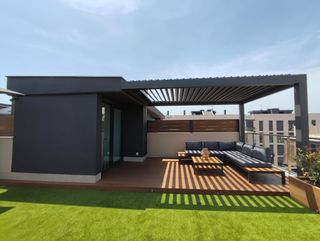 Terraza moderna con pérgola y sofás