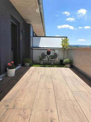 Terraza moderna con pérgola y sofás