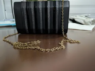 Bolso de mano negro con cadena dorada