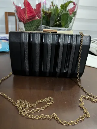 Bolso de mano negro con cadena dorada