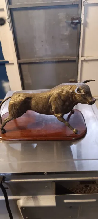 Toro de bronce sobre base de madera