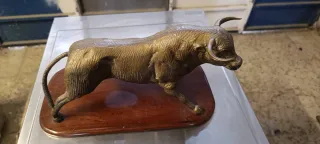 Toro de bronce sobre base de madera