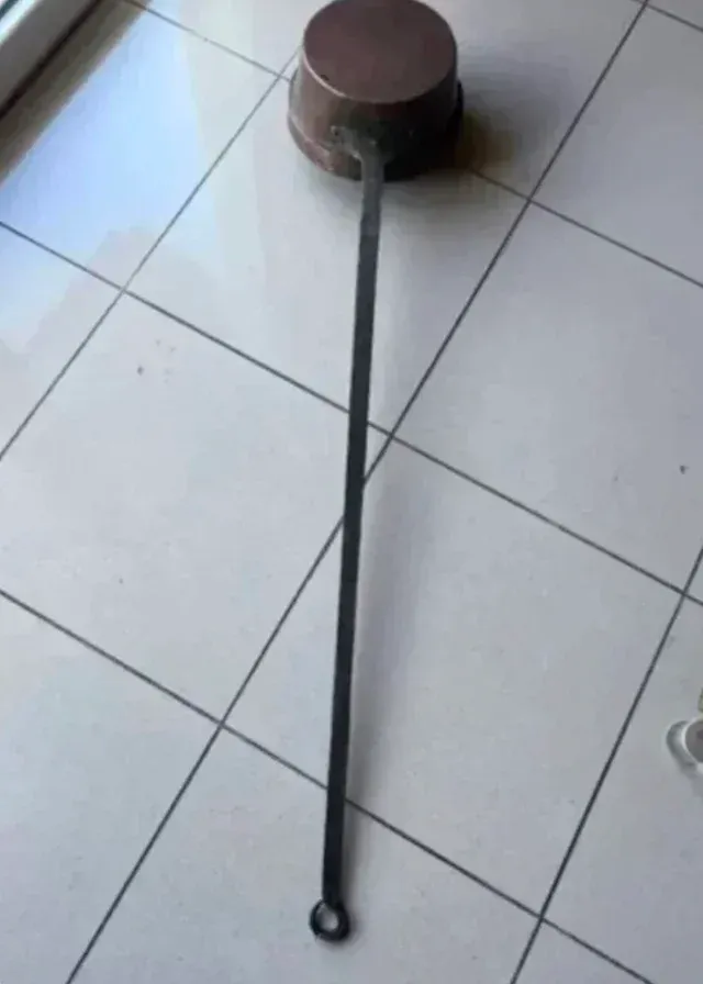 Antico riscaldatore in rame con manico in ferro