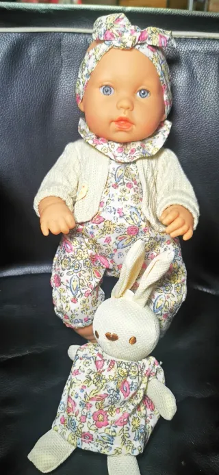 Muñeca bebé con vestido floral y peluche
