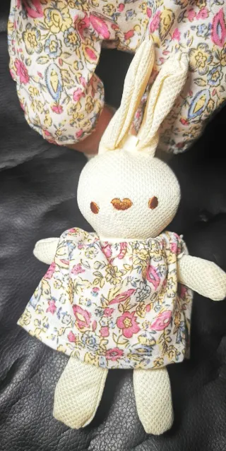 Muñeca bebé con vestido floral y peluche