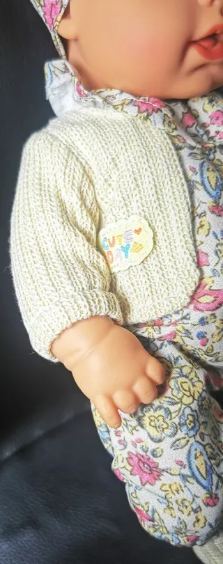 Muñeca bebé con vestido floral y peluche