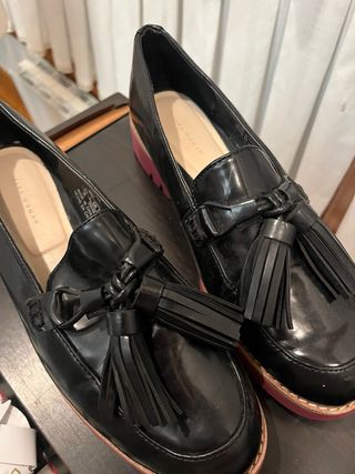 Mocasines negros con suela roja y flecos