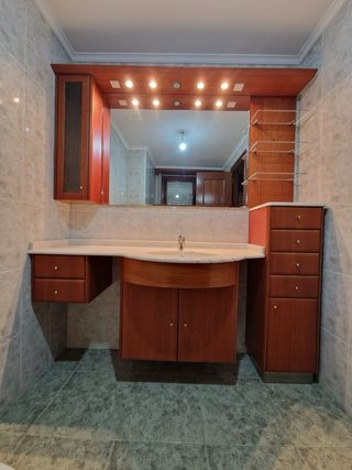 Mueble de baño madera y mármol con lavabo.