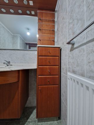 Mueble de baño madera y mármol con lavabo.