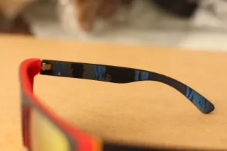 Gafas de sol rojas con lentes brillantes.