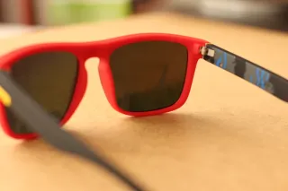 Gafas de sol rojas con lentes brillantes.