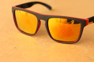 Gafas de sol rojas con lentes brillantes.