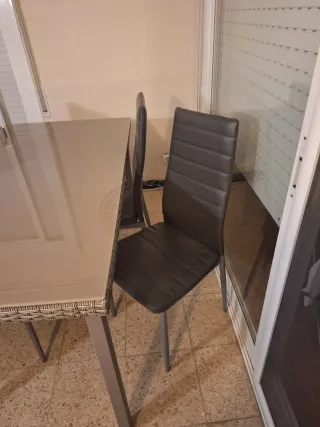 Sofá cama con mesa de centro y mesa con sillas