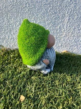 Gnomo de jardín pequeño con gorro de césped.