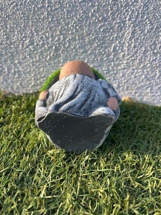 Gnomo de jardín pequeño con gorro de césped.