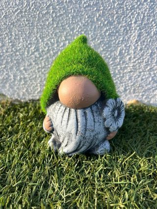 Gnomo de jardín pequeño con gorro de césped.