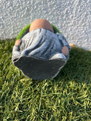 Gnomo de jardín pequeño con gorro de césped.