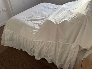 Faldón de cama blanco con volantes.