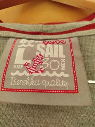 Chaquetilla con capucha gris y detalles rojos