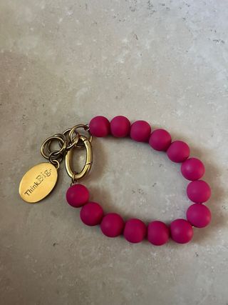 Bracciale palline fucsia con ciondolo oro