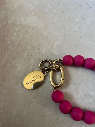 Bracciale palline fucsia con ciondolo oro