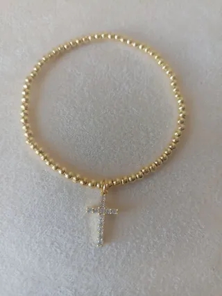 Pulsera dorada con colgante de cruz