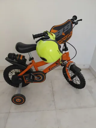 Bicicleta infantil naranja con casco