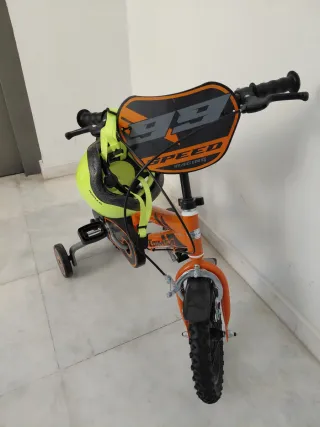 Bicicleta infantil naranja con casco