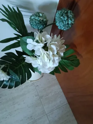 Jarrón blanco con flores y tapete