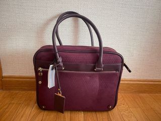 Bolso portátil color burdeos.