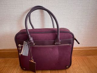 Bolso portátil color burdeos.