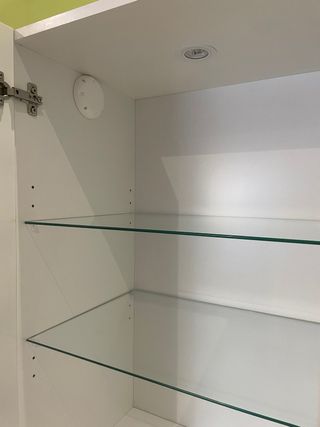 Mueble de baño blanco con puertas de cristal